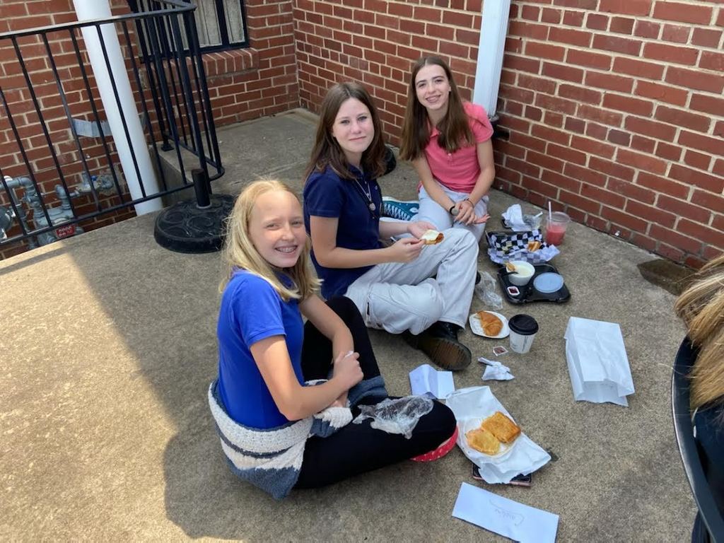 students eating lunch on sidewalk